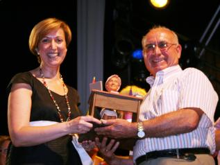 Araújo recibe del presidente de la asociación vecinal, Cirilo Ramiro, una estatuilla de su propia imagen.